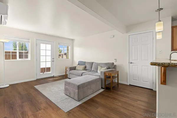 a living room with furniture and a wooden floor