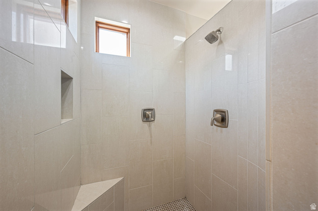 2331 West Entrada Trail, Unit 61 St. George, UT 84770 - Photo 30 of 69 Tiled shower enclosure featuring dual shower heads, a built-in bench, a recessed niche, and a contrasting mosaic tile floor