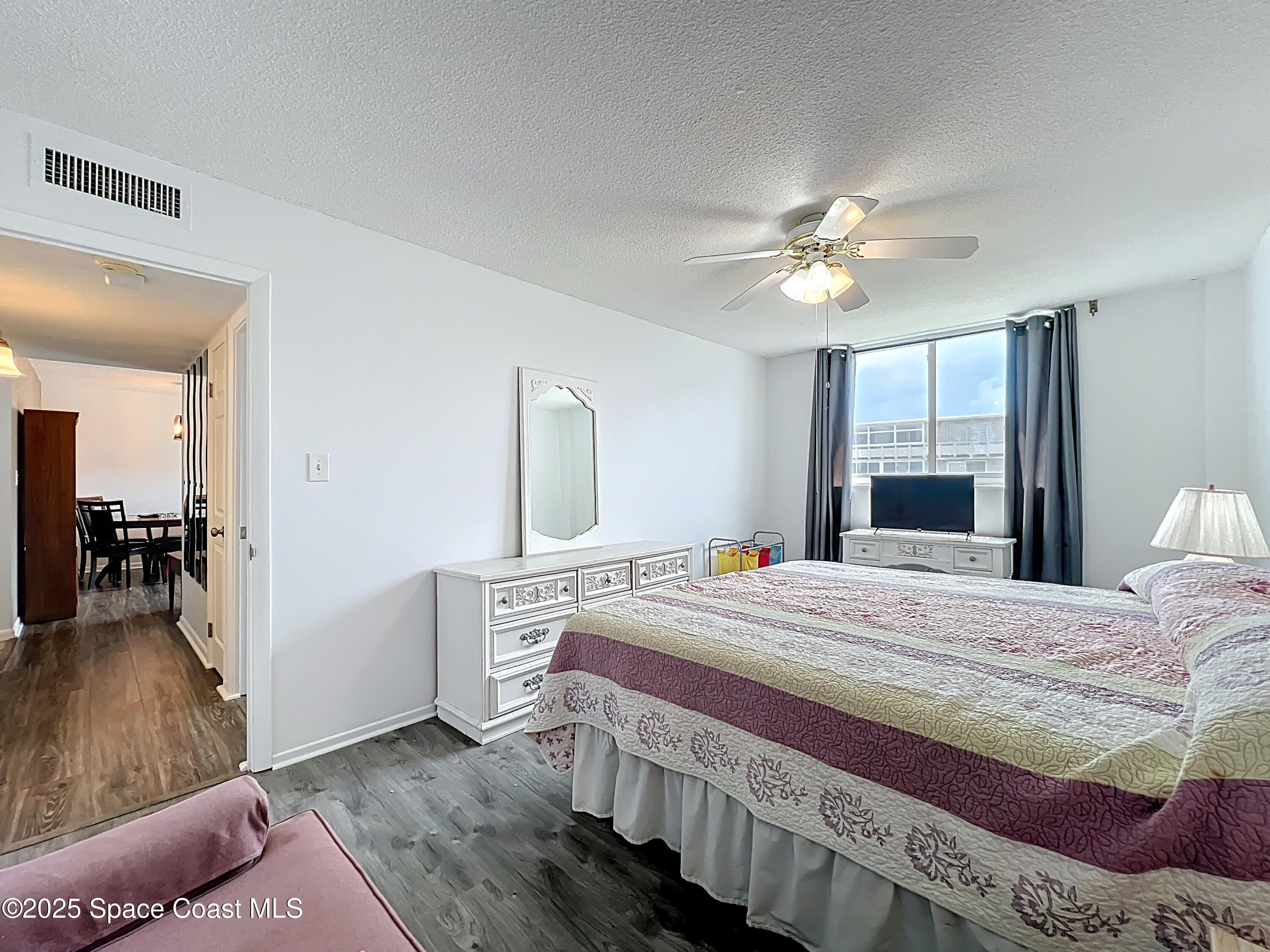 2020 North Atlantic Avenue, Unit 514N Cocoa Beach, FL 32931 - Photo 13 of 31 a bedroom with a bed and a chandelier