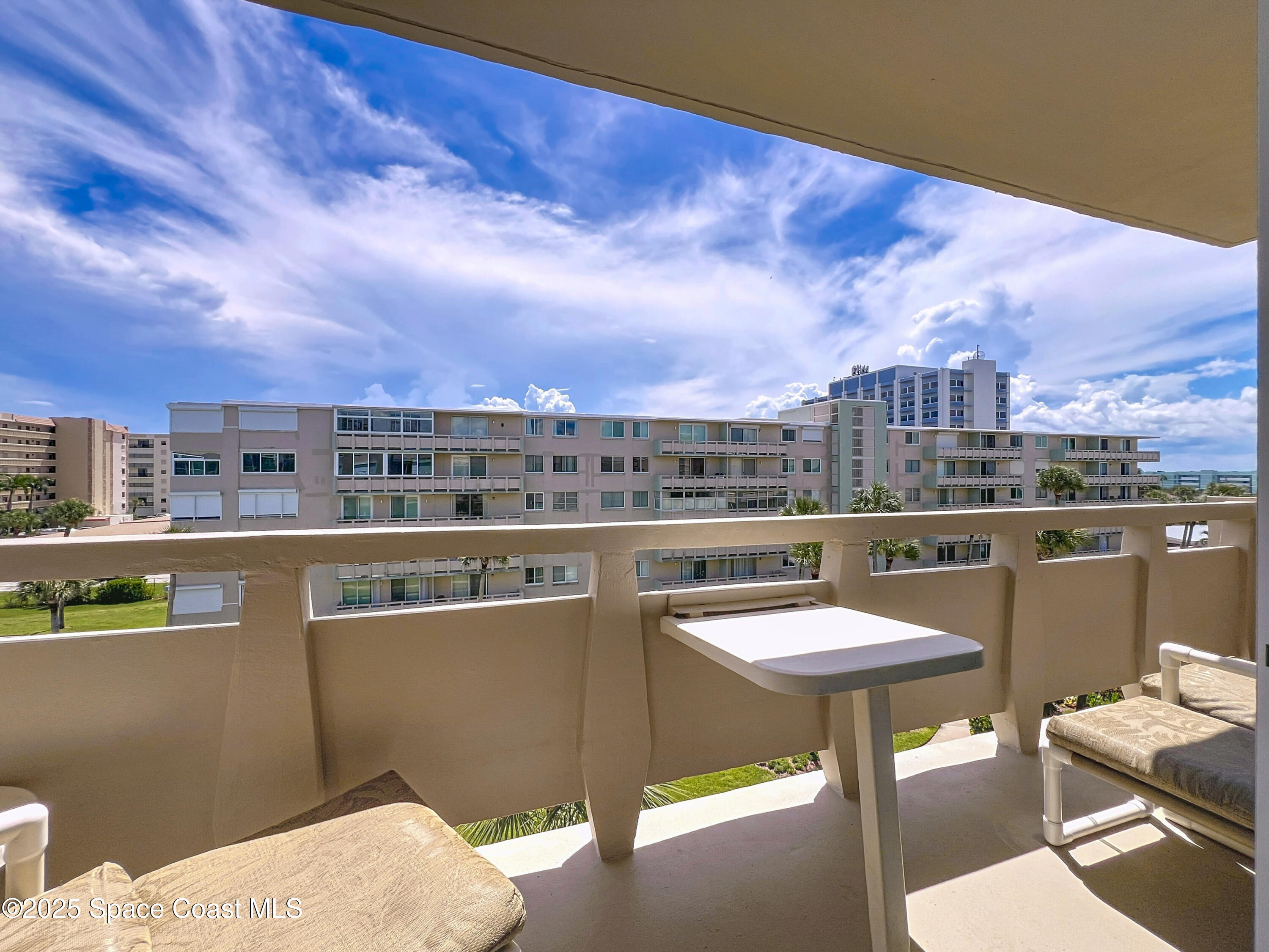 2020 North Atlantic Avenue, Unit 514N Cocoa Beach, FL 32931 - Photo 18 of 31 a view of a chairs and table in a terrace