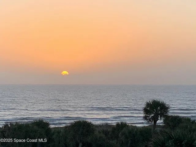 a view of a patio with lawn chairs under an umbrella