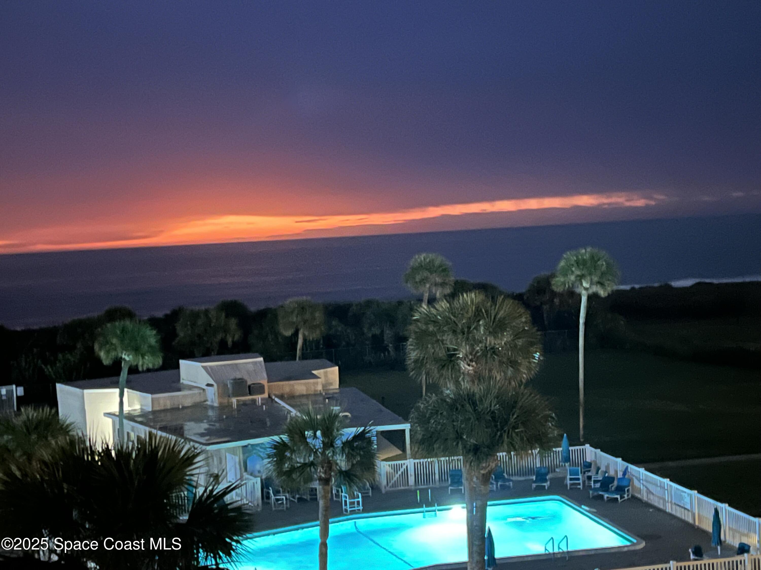 2020 North Atlantic Avenue, Unit 514N Cocoa Beach, FL 32931 - Photo 30 of 31 a view of a patio with lawn chairs under an umbrella