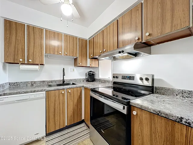 a kitchen with granite countertop a sink and a stove