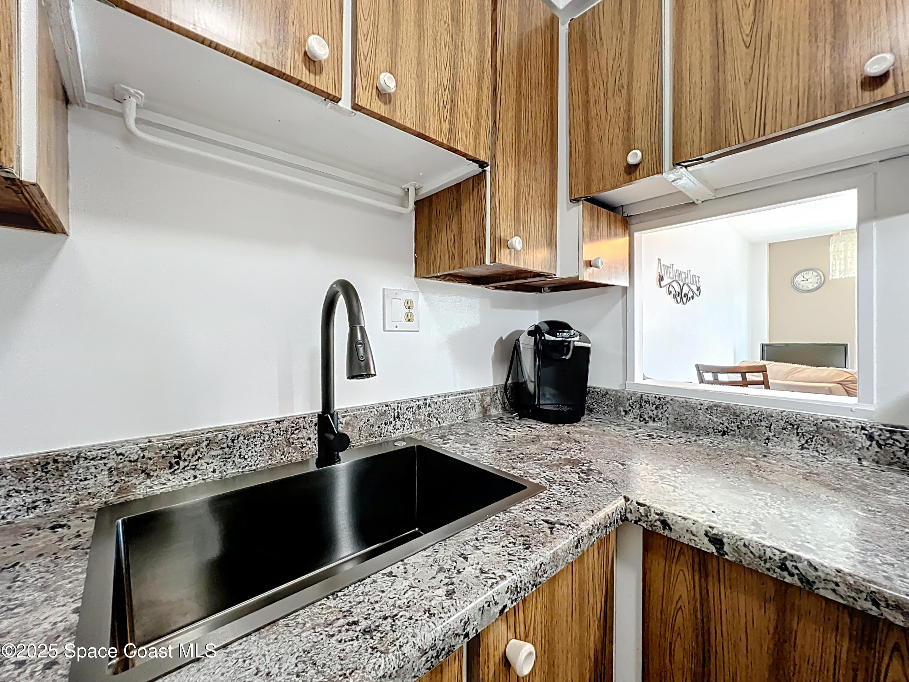 2020 North Atlantic Avenue, Unit 514N Cocoa Beach, FL 32931 - Photo 6 of 31 a kitchen with granite countertop a sink and a stove