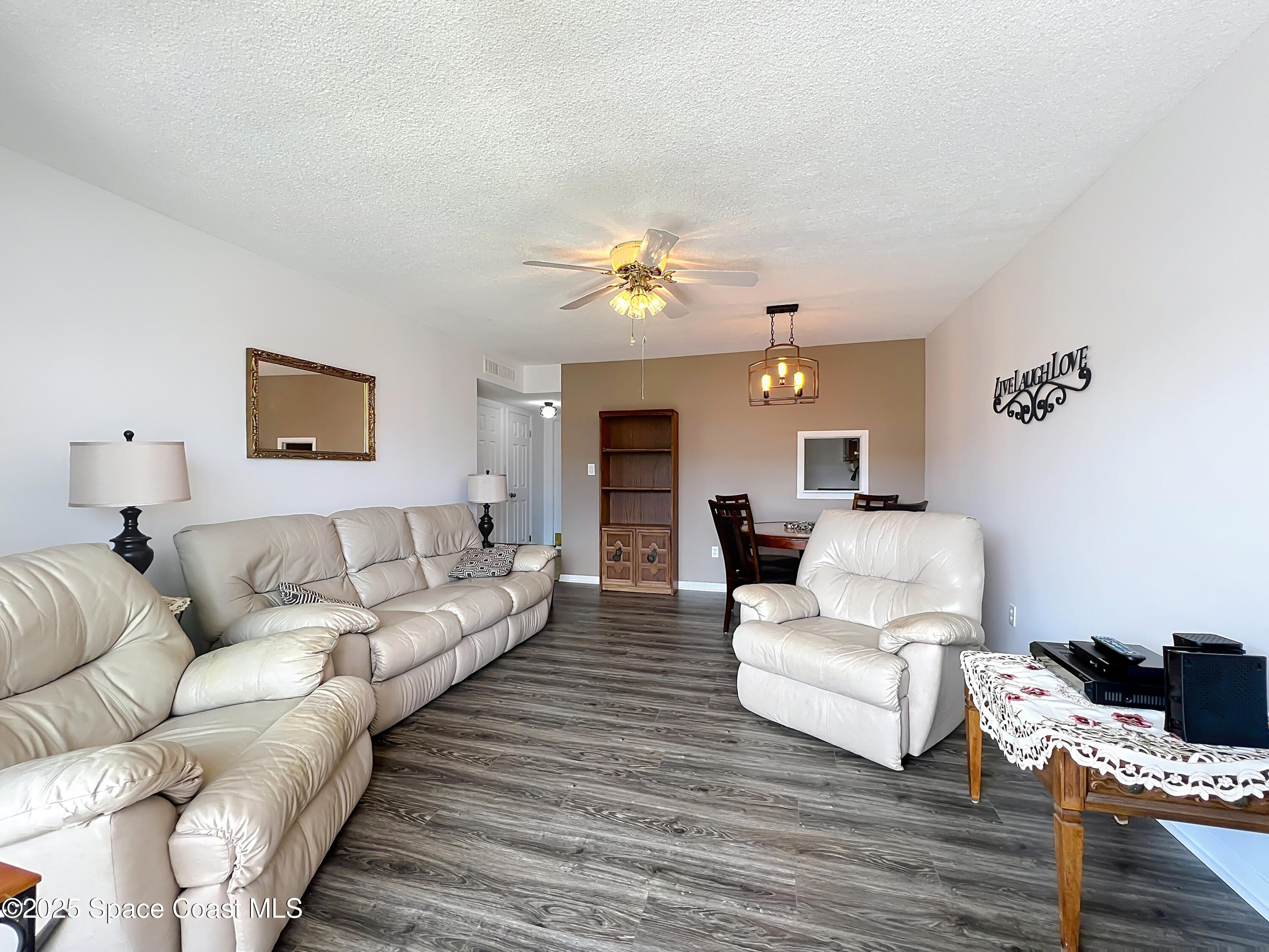 2020 North Atlantic Avenue, Unit 514N Cocoa Beach, FL 32931 - Photo 10 of 31 a living room with furniture and a chandelier