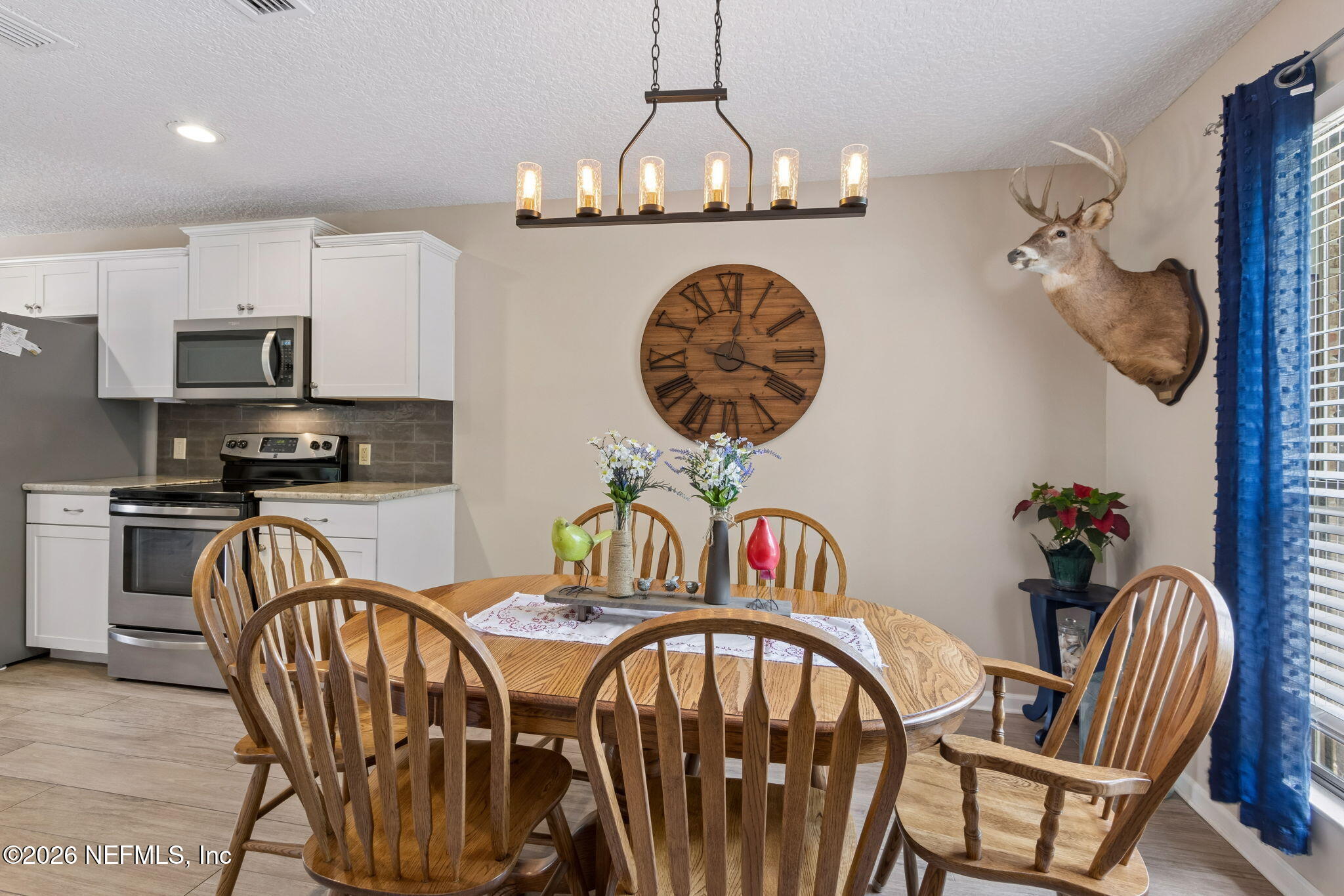 3194 Creighton Landing Road Fleming Island, FL 32003 - Photo 11 of 31 a kitchen with stainless steel appliances granite countertop a dining table chairs and a chandelier