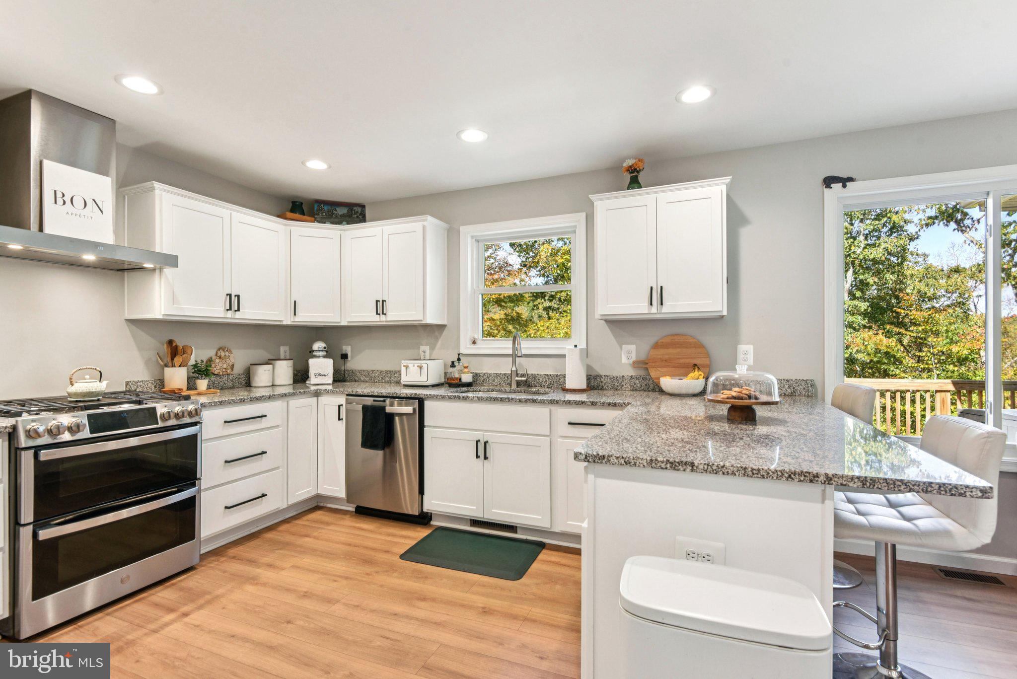490 Black Twig Road Linden, VA 22642 - Photo 18 of 67 a kitchen with a stove a sink a microwave and wooden cabinets