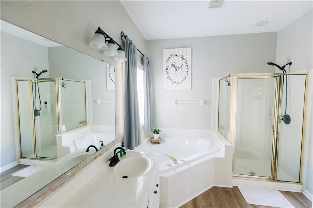 2533 Gold Hill Court Villa Rica, GA 30180 - Photo 23 of 46 a bathroom with a tub a sink and a large mirror