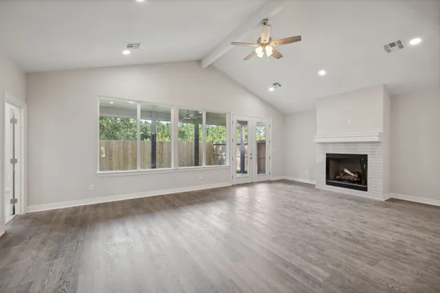 a view of an empty room with a fireplace and a window