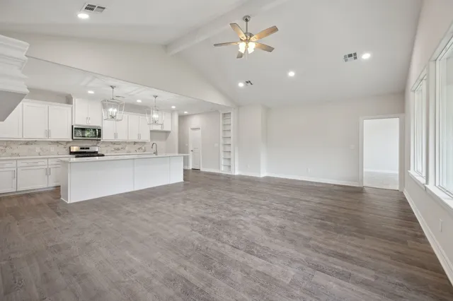 a view of kitchen with kitchen island wooden floor center island and stainless steel appliances