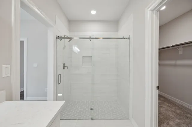 a bathroom with a shower and a glass door