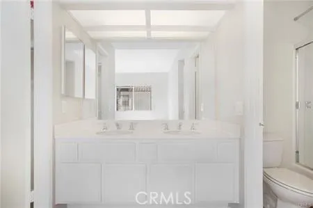 a bathroom with a sink vanity mirror and toilet