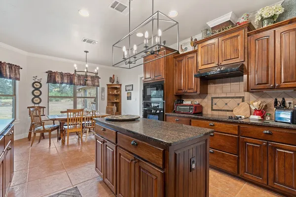 a kitchen with granite countertop a sink a counter top space appliances and cabinets
