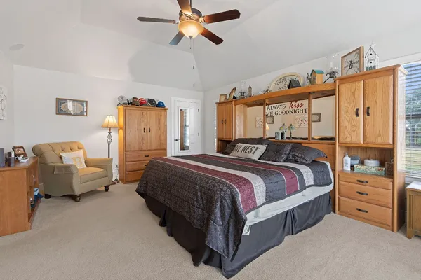 a spacious bedroom with a bed and a chandelier