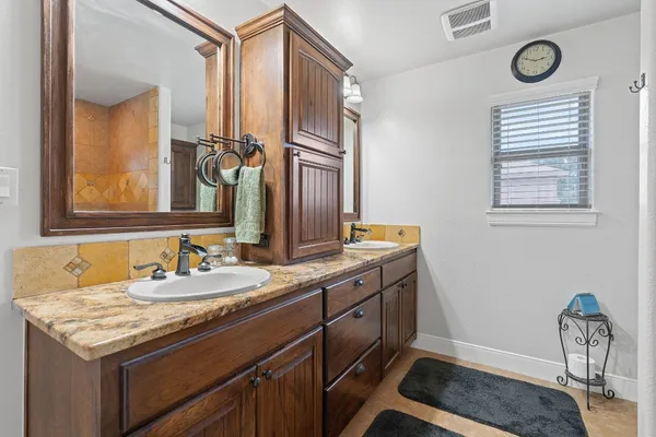 a bathroom with a granite countertop sink and a mirror