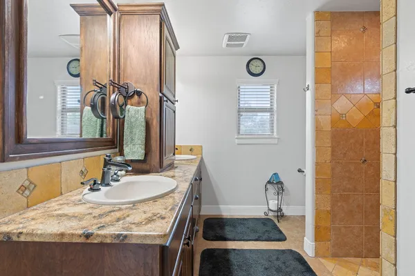 a bathroom with a granite countertop sink and a mirror
