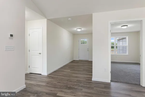 an empty room with wooden floor & windows