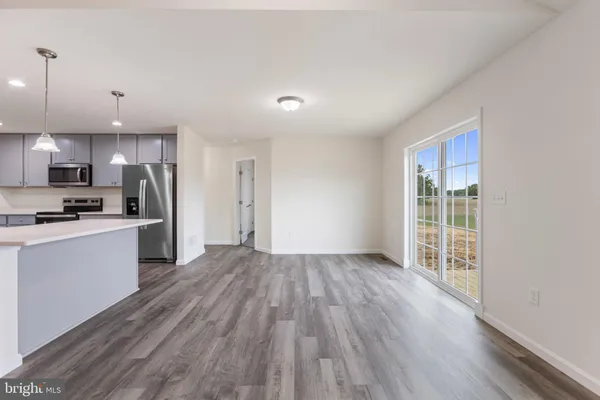 a kitchen with wooden floors appliances and cabinets