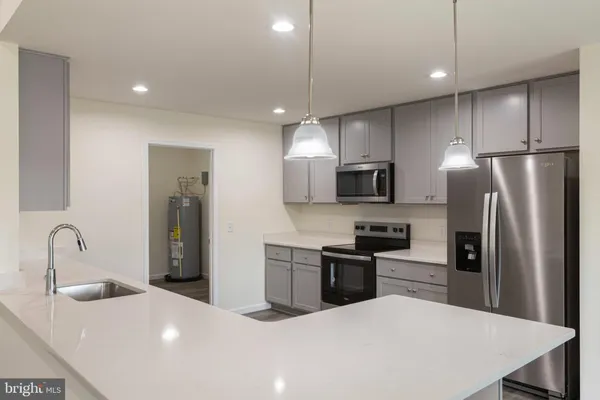 a kitchen with stainless steel appliances granite countertop a refrigerator a sink a stove a microwave and island