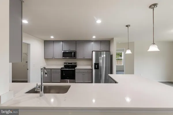 a kitchen with stainless steel appliances kitchen island granite countertop a refrigerator a stove and a sink