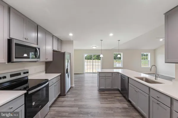 a large kitchen with a large counter top stainless steel appliances and cabinets