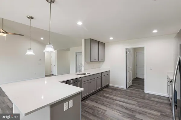 a large kitchen with a sink and a refrigerator