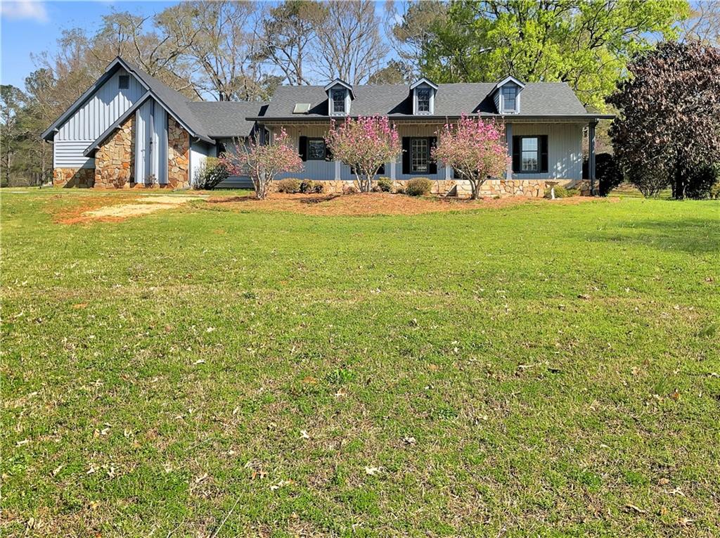 a view of a house with a yard and sitting area