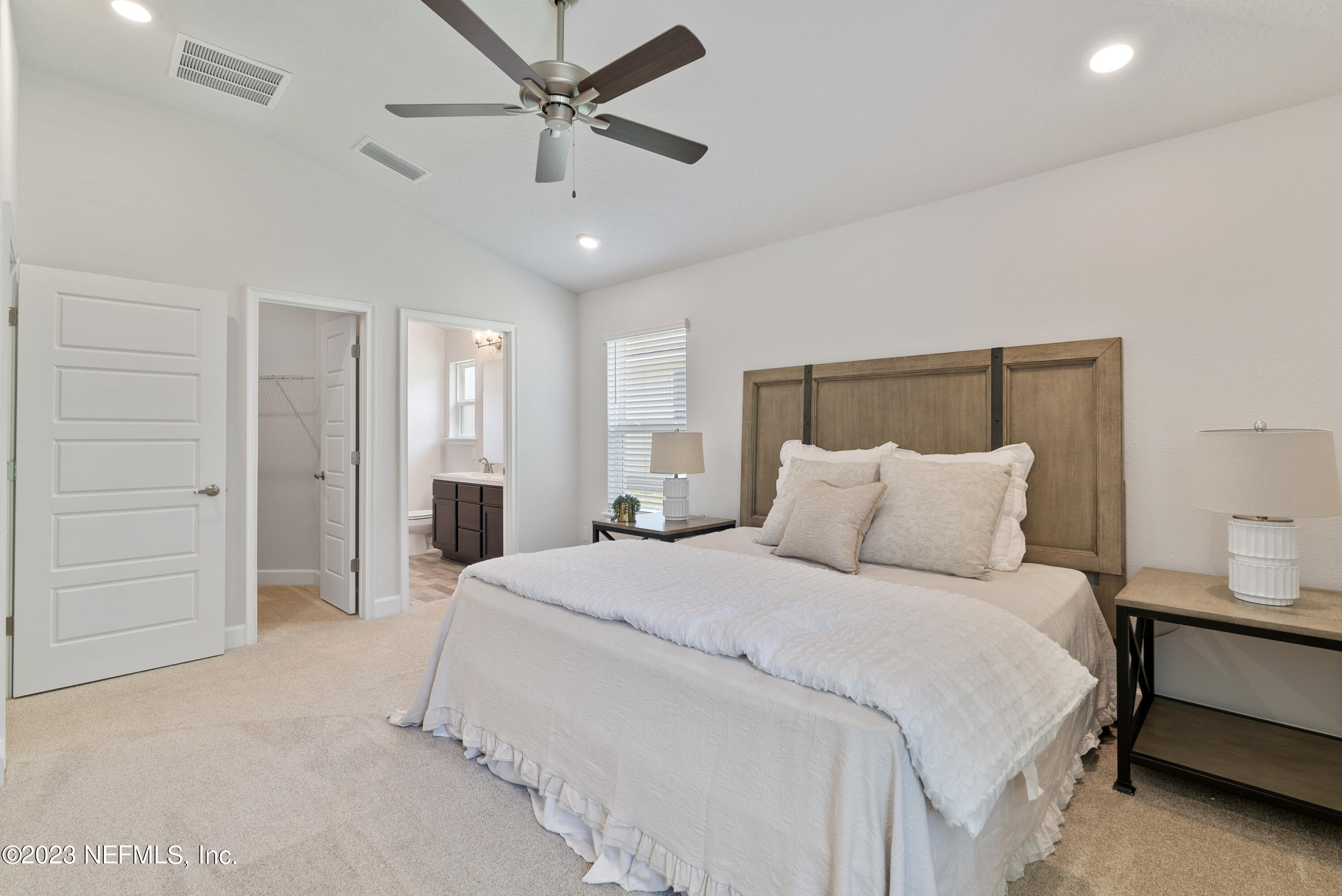 7833 Driggers Street Jacksonville, FL 32220 - Photo 14 of 26 a spacious bedroom with a bed and a chandelier