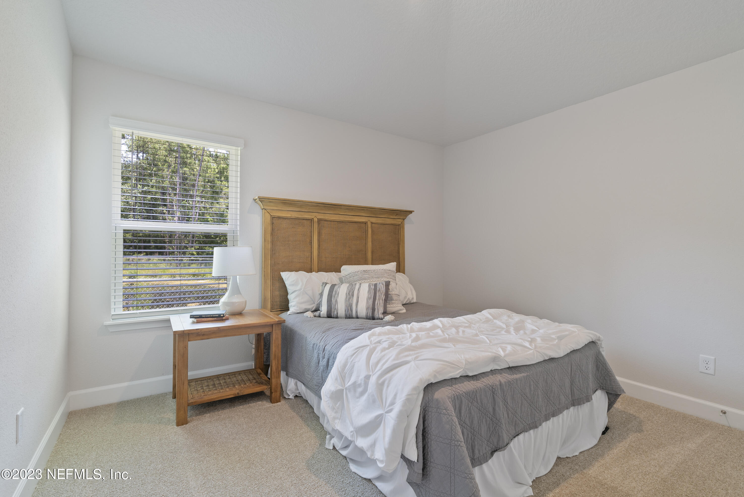 7833 Driggers Street Jacksonville, FL 32220 - Photo 20 of 26 a bedroom with a bed chair and a window