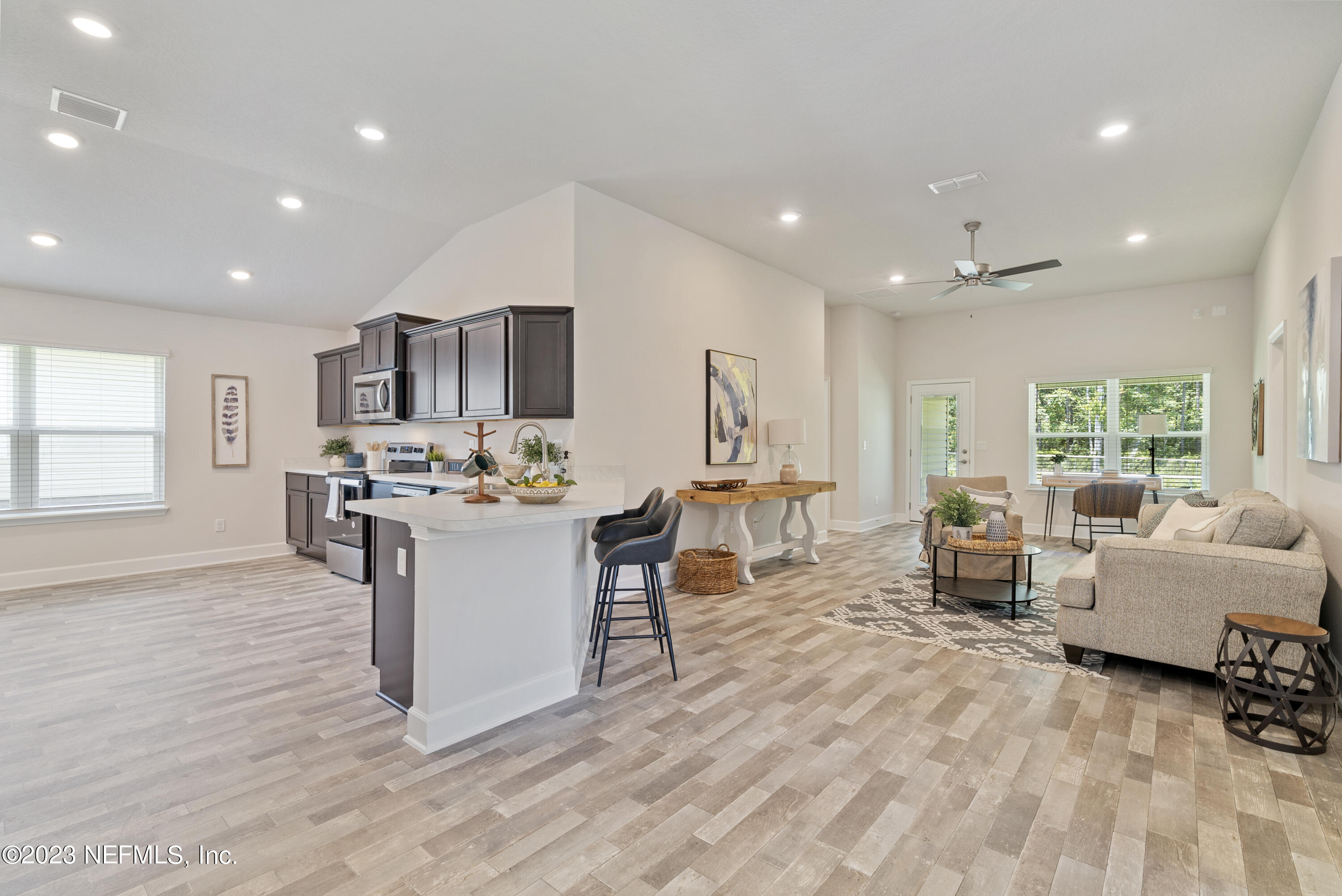 7833 Driggers Street Jacksonville, FL 32220 - Photo 2 of 26 a living room with couches and kitchen view with wooden floor
