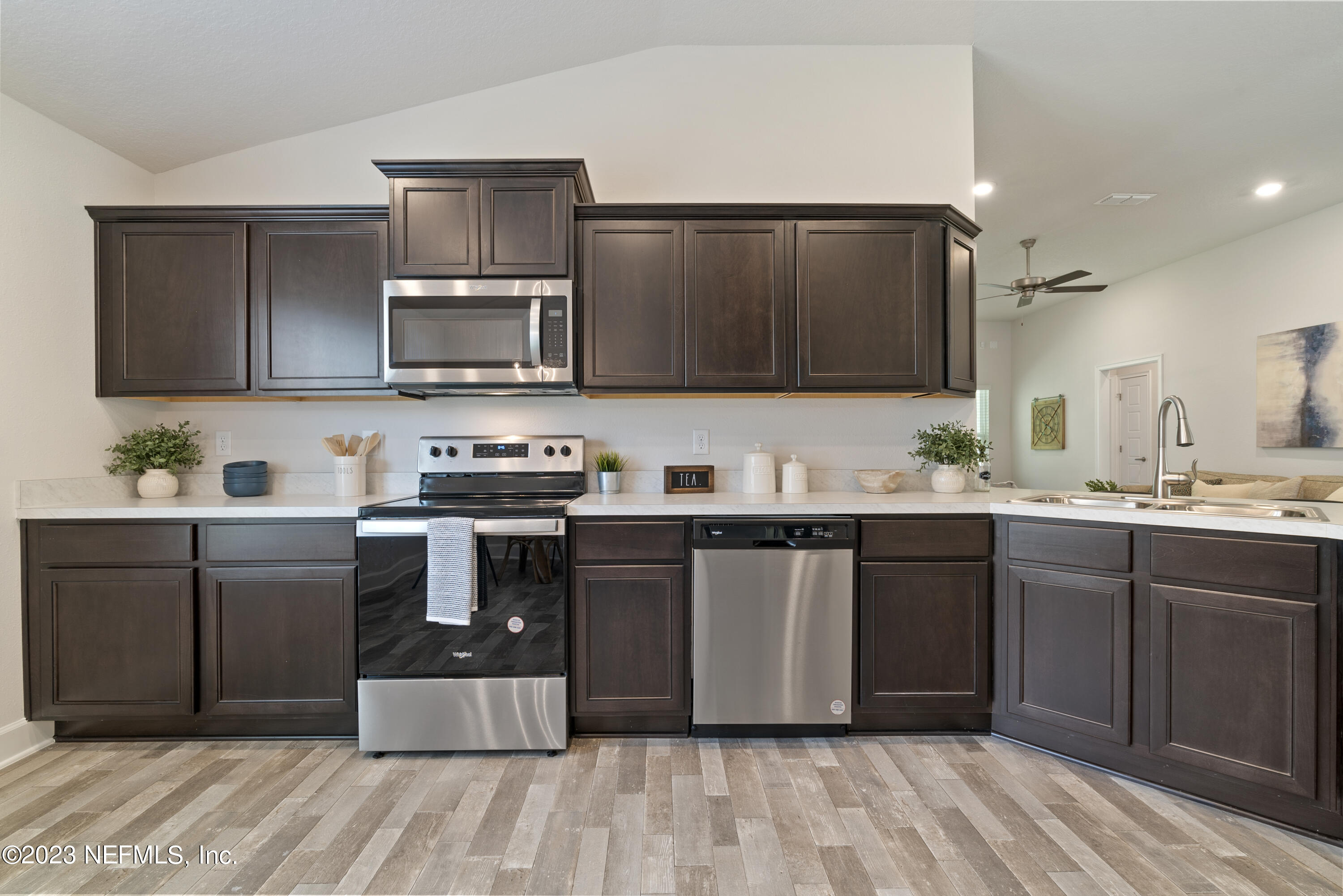 7833 Driggers Street Jacksonville, FL 32220 - Photo 4 of 26 a kitchen with stainless steel appliances granite countertop a stove a sink dishwasher and a microwave oven on the wooden floor