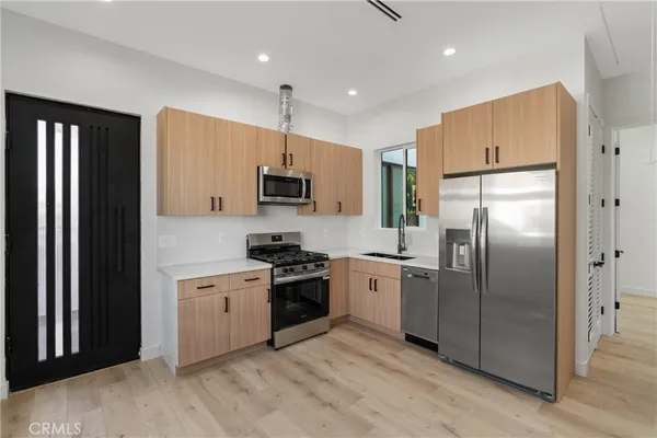 a kitchen with stainless steel appliances granite countertop a refrigerator a stove a sink and a refrigerator