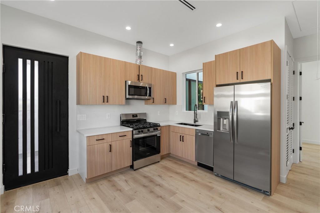 a kitchen with stainless steel appliances granite countertop a refrigerator a stove a sink and a refrigerator