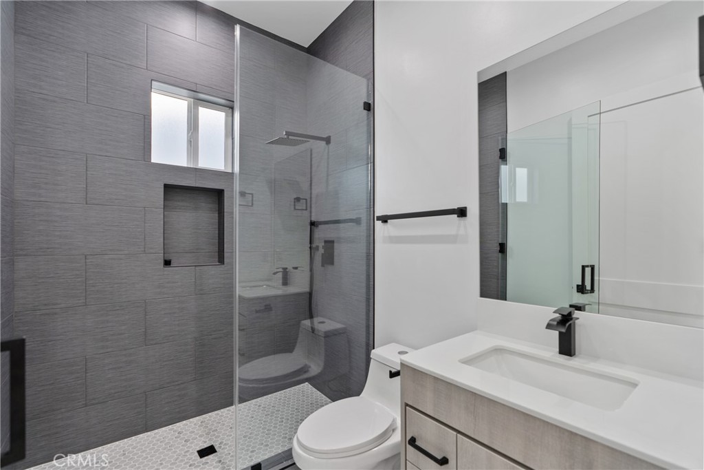 17313 Los Alimos Street, Unit 1/2 Granada Hills, CA 91344 - Photo 3 of 6 a bathroom with a sink a toilet and shower