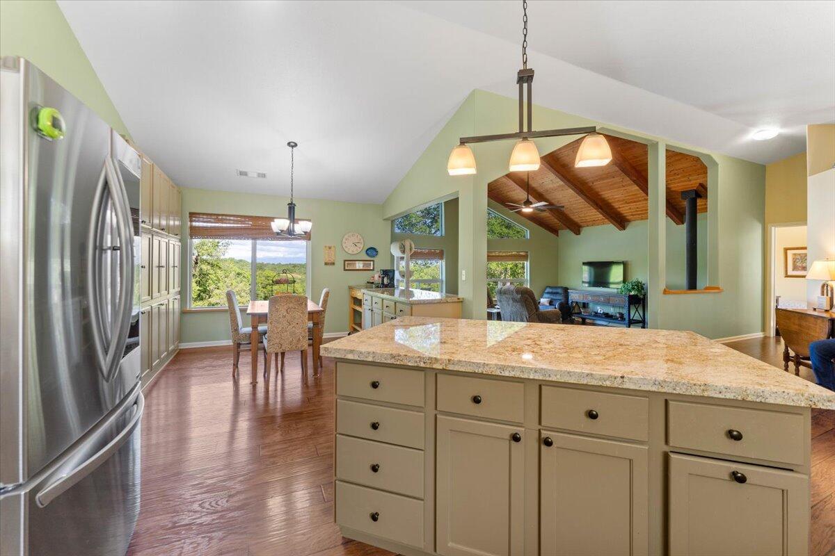 20410 Mallorca Lane Red Bluff, CA 96080 - Photo 3 of 37 a dining hall with stainless steel appliances kitchen island granite countertop a table chairs and a view of living room