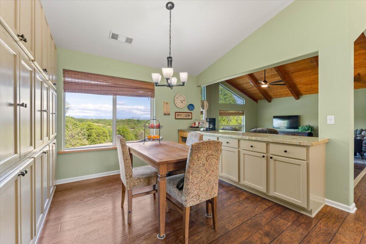 20410 Mallorca Lane Red Bluff, CA 96080 - Photo 10 of 37 a dining room with wooden floor a chandelier a wooden table and chairs