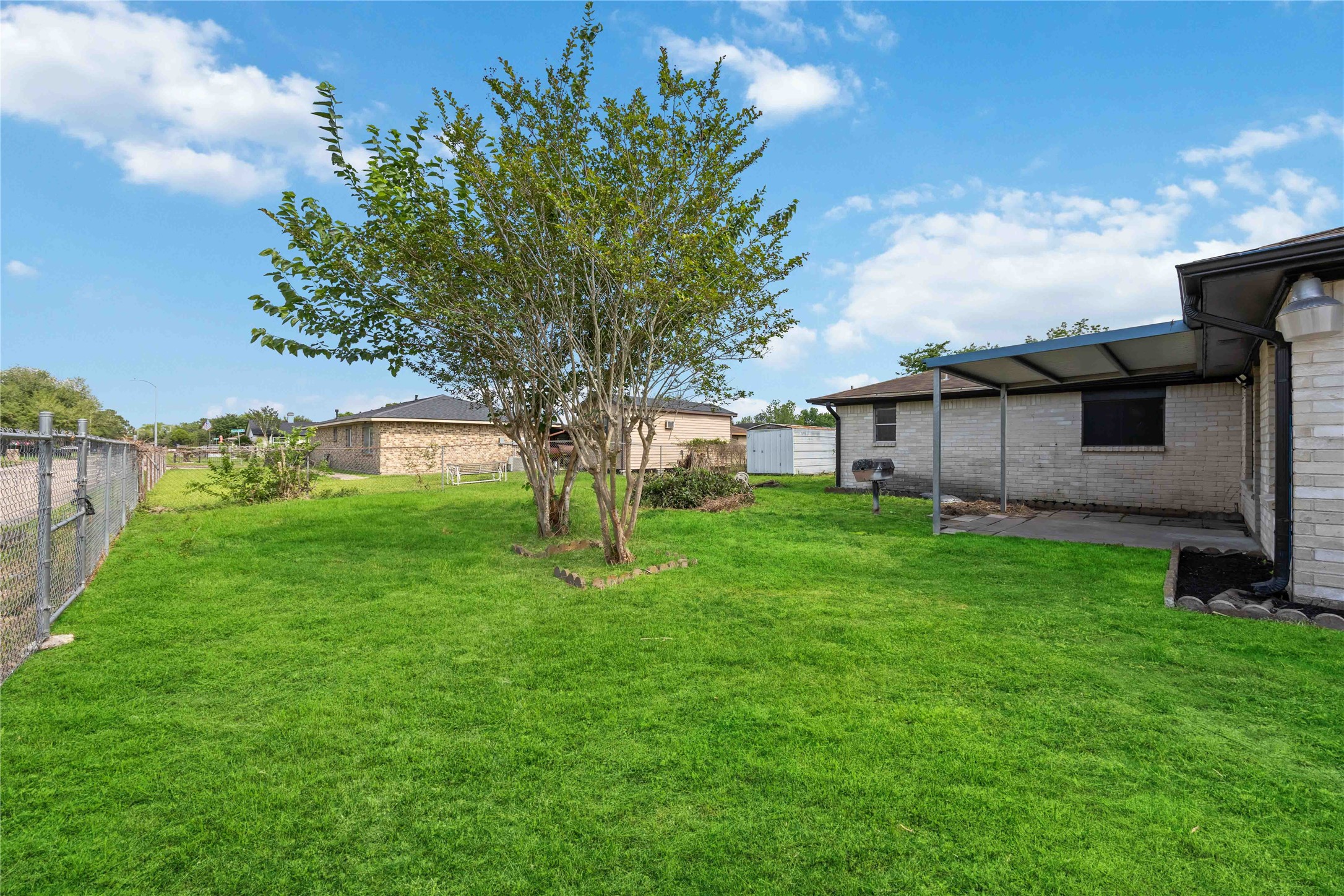 12703 Redfern Drive Houston, TX 77048 - Photo 24 of 28 Expansive backyard with lush lawn and mature trees—an inviting outdoor setting perfect for entertaining, relaxing, or creating your own private retreat.