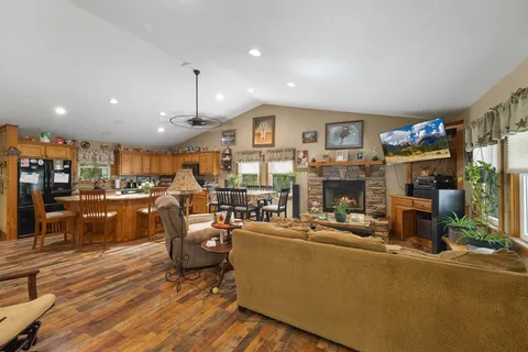 a living room with fireplace furniture and a kitchen view