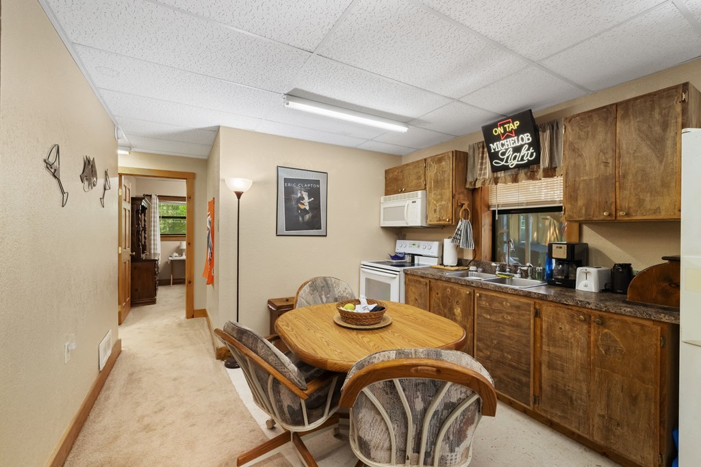 77 Chosen Ridge Morganton, GA 30560 - Photo 30 of 37 a kitchen with a stove a refrigerator a sink a dining table and chairs with wooden floor