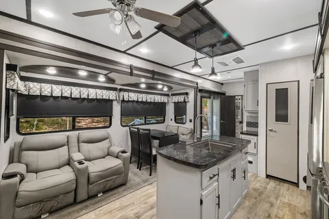 a living room with furniture a fireplace and a chandelier