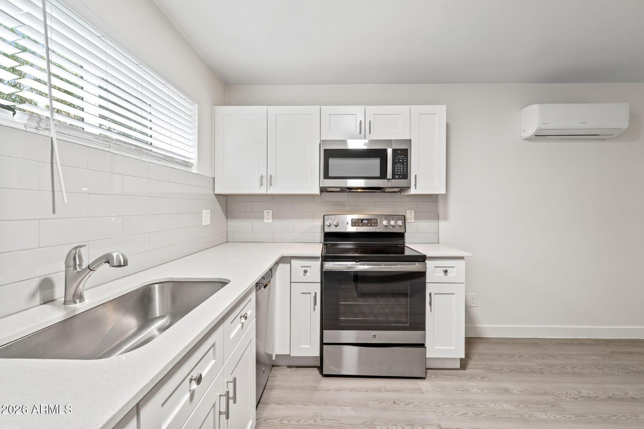 1707 North 18th Street, Unit B7 Phoenix, AZ 85006 - Photo 8 of 14 a kitchen with stainless steel appliances granite countertop a sink stove and microwave