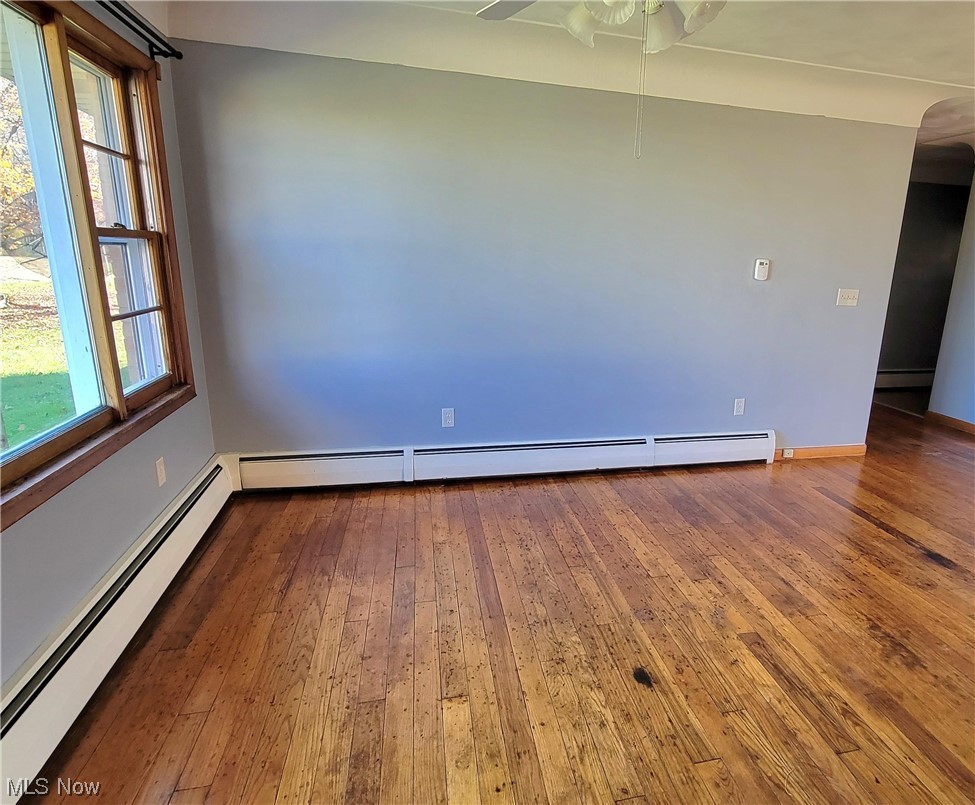 405 Bryan Road Milan, OH 44846 - Photo 11 of 35 dining room featuring dark hardwood / wood-style floors, ceiling fan, and a baseboard radiator
