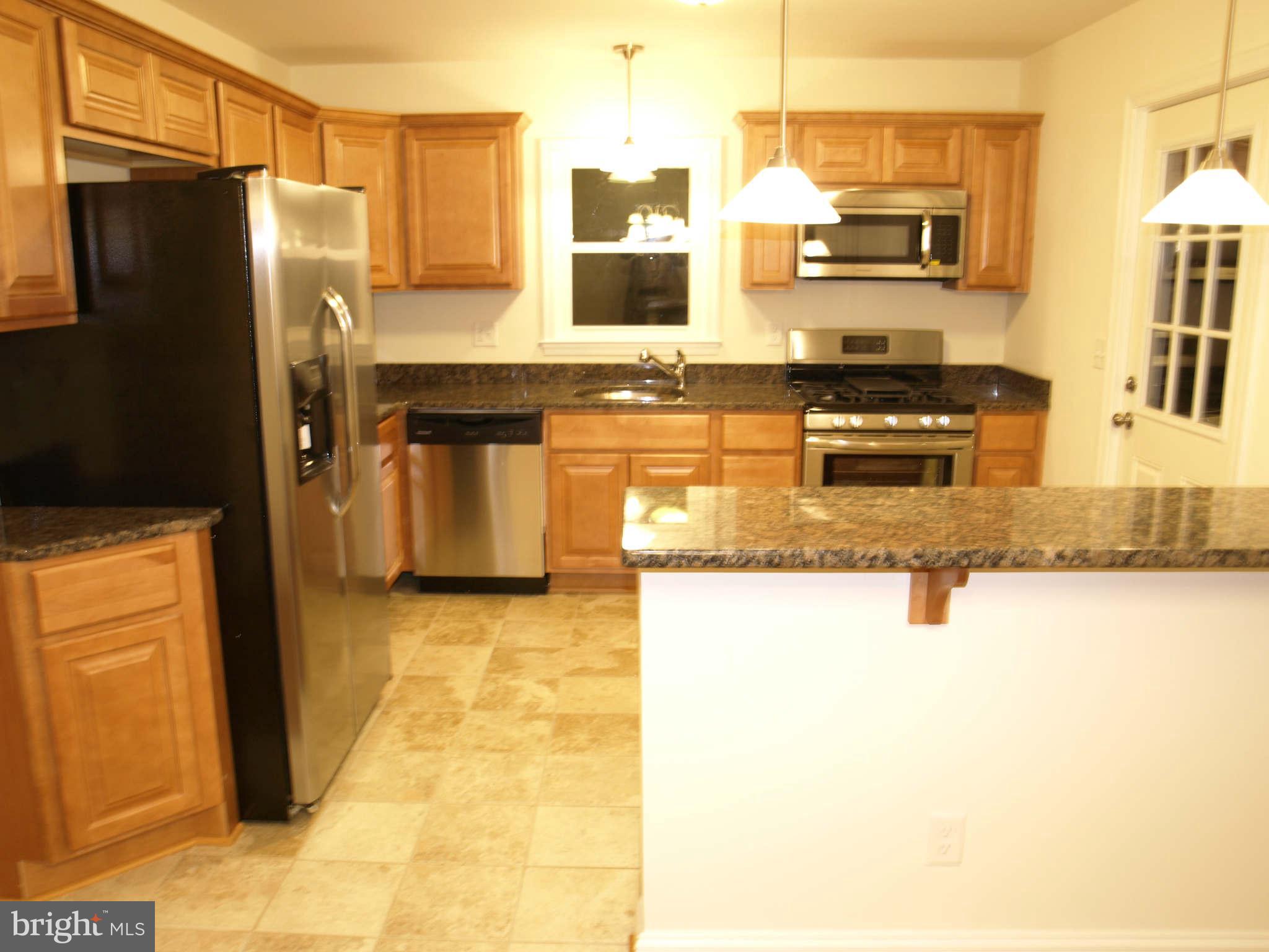 1500 Brian Road Baltimore, MD 21237 - Photo 14 of 30 a kitchen with stainless steel appliances granite countertop a refrigerator a stove and a sink with granite countertops