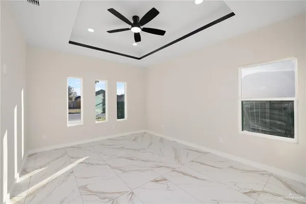 a view of an empty room with a window and a ceiling fan