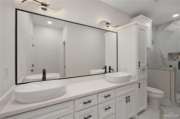 a bathroom with a sink and a mirror with toilet