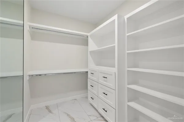 a view of walk in closet with empty racks