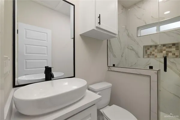 a white toilet sitting next to a bathroom sink