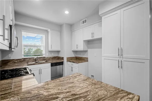 a kitchen with a stove a refrigerator and a sink