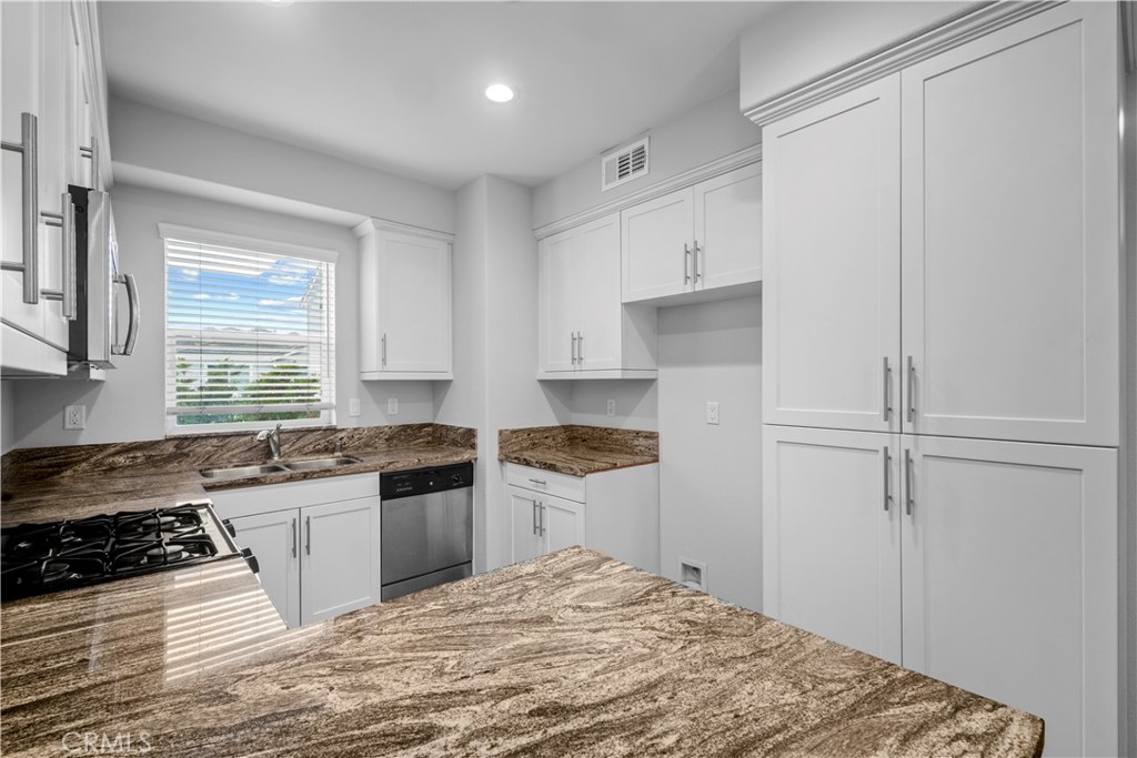 4617 Alekona Ct. Cypress, CA 90630 - Photo 17 of 35 a kitchen with a stove a refrigerator and a sink