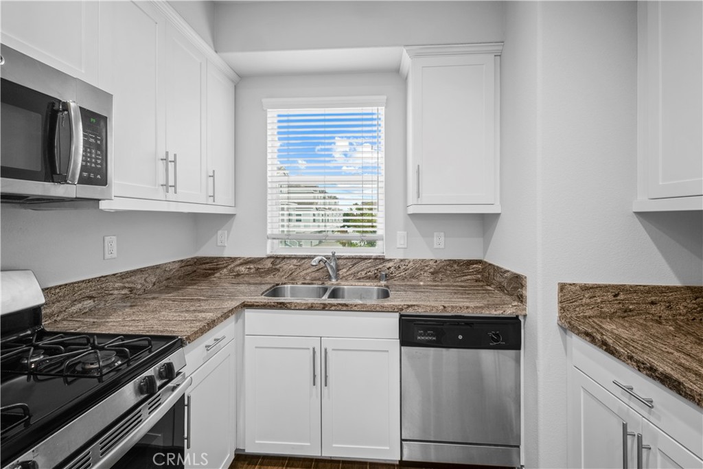 4617 Alekona Ct. Cypress, CA 90630 - Photo 18 of 35 a kitchen with granite countertop a sink stove and cabinets